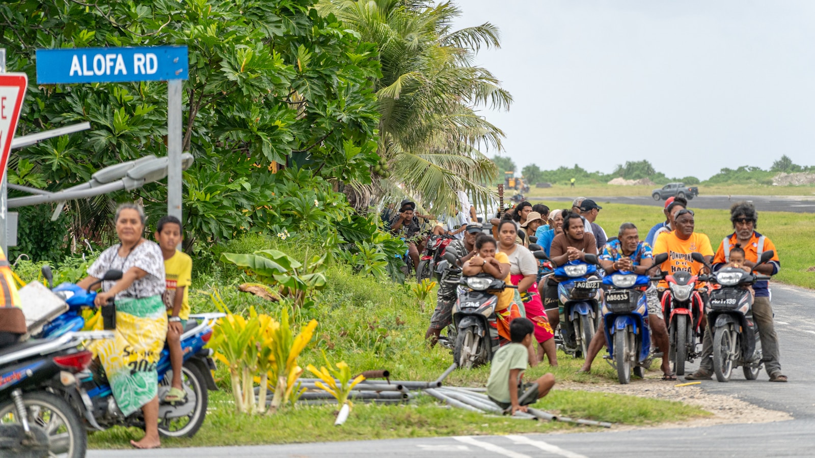 A group of people riding motorcycles down a street