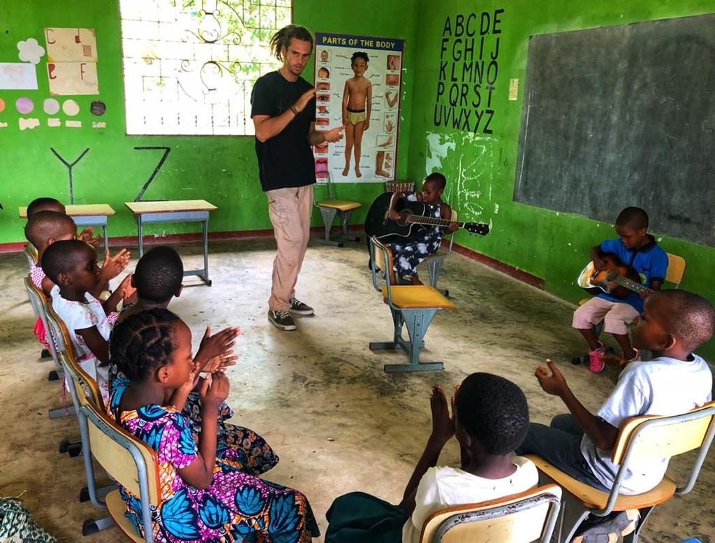 Participant teaching music to the students People swim in a refreshing waterfall.