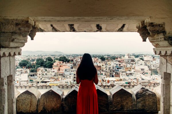 person in red hoodie standing on top of building during daytime
